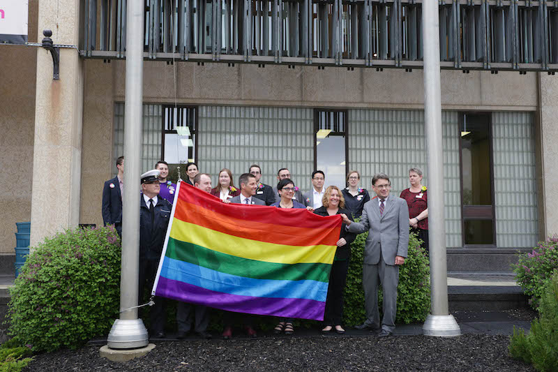 Group of Manitoba leaders holding a pride flag for the Pride Flag Raising Event