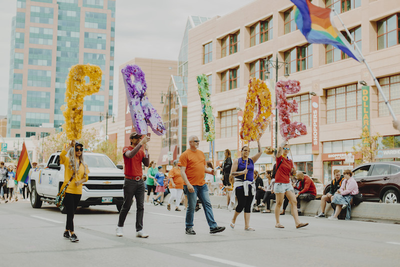 people holding pride letter signage