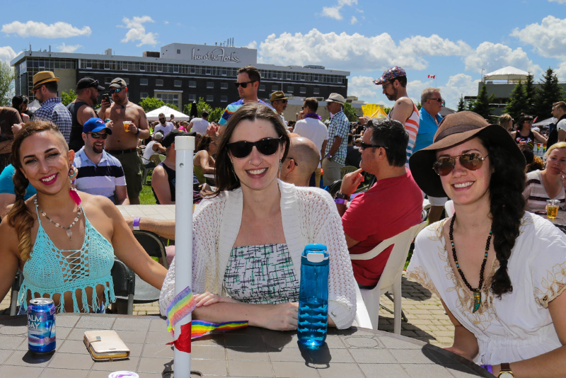 three people sitting and a bottle of water on a table
